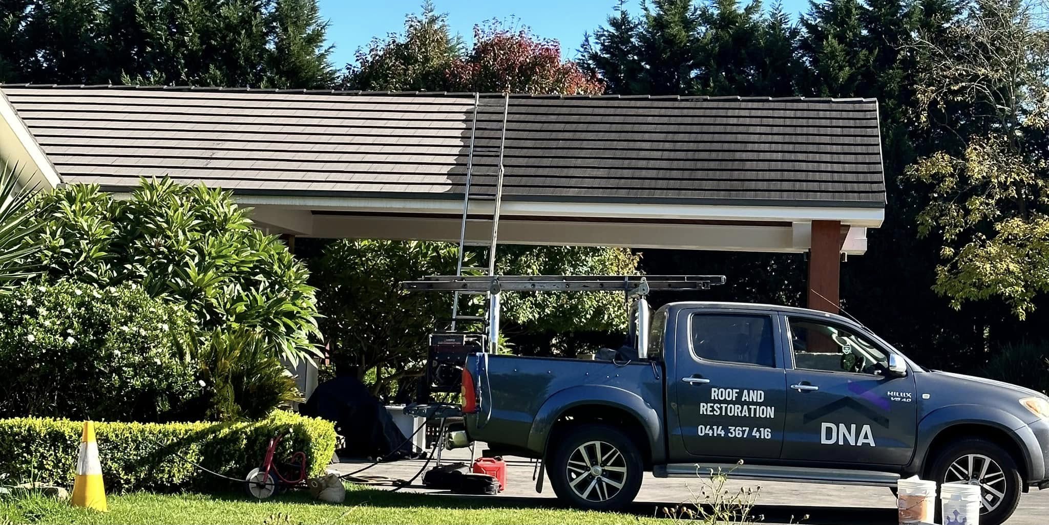 DNA Roof branded ute on site with tiled roof half restored — before and after in one shot